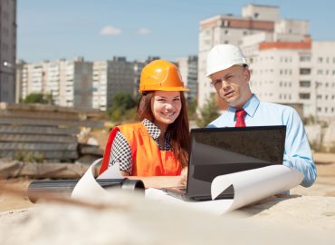 Portrait of two builders standing at building site